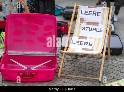 Schwerin, Deutschland. April 2020. Mit leeren Koffern und Liegestühlen stehen Eigentümer und Mitarbeiter von Reisebüros während einer Protestaktion vor der Staatskanzlei. Angesichts der niedrigen Infektionsraten in Mecklenburg-Vorpommern fordern Reiseexperten eine Normalisierung in der Koronakrise. Bis zu 50 Vertreter von Reiseveranstaltern nutzen die Aktion, um auf ihre schwierige wirtschaftliche Situation aufmerksam zu machen. Aufgrund der aktuellen Corona-Entfernungsregeln sind keine weiteren Teilnehmer erlaubt. Quelle: Jens Büttner/dpa-Zentralbild/dpa/Alamy Live News Stockfoto