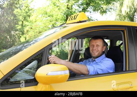 Schöner Taxifahrer im Auto sitzend Stockfoto