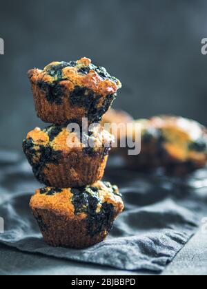 Hausgemachte vegan blueberry muffins auf dunklem Hintergrund. Stapel von drei Ei-Muffins mit Kopie Platz für Text oder Design. Low Key. Vertikale. Stockfoto