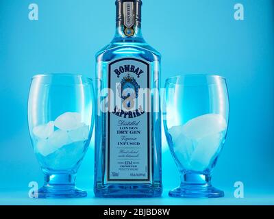 Flasche Bombay Sapphire Gin Kelch mit Eis und blauem Hintergrund unter Kelch Rand Ansicht Stockfoto