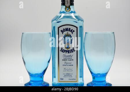 Flasche Bombay Sapphire Gin mit zwei Kelchen weißen Hintergrund Stockfoto