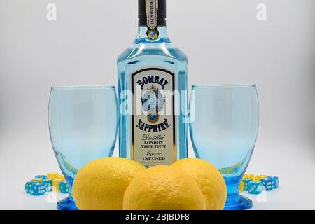 Flasche Bombay Sapphire Gin mit zwei Kelchen und Zitronen weißen Hintergrund Stockfoto