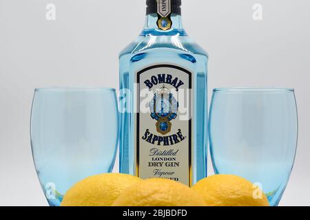 Flasche Bombay Sapphire Gin mit zwei Kelchen und Zitronen weißen Hintergrund Stockfoto