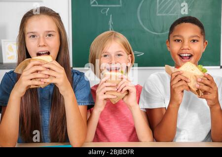 Schüler mit Mittagessen im Klassenzimmer Stockfoto