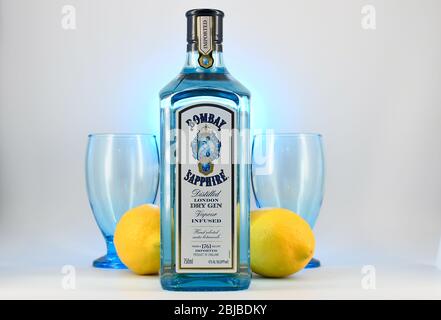 Flasche Bombay Sapphire Gin mit zwei Kelchen und Zitronen weißen Hintergrund Stockfoto