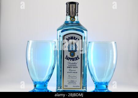 Flasche Bombay Sapphire Gin mit zwei Kelchen weißen Hintergrund Stockfoto