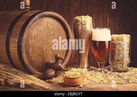 Bierfass mit Hopfen und Gerste auf Holzhintergrund Stockfoto