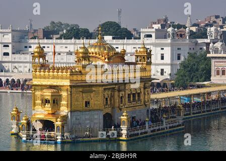 Die Anbeter stehen an einem der am meisten verehrten Orte für Sikhs: Harmandir Sahib (Goldener Tempel) steht im See von Nectar, Amritsar, Punjab, Indien. Stockfoto