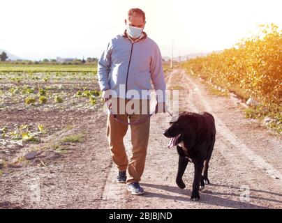 Ein Mann geht mit seinem Hund im Freien, nachdem Spanien eine Sperre auferlegt hatte, um die Ausbreitung der Coronavirus-Krankheit zu verlangsamen. Stockfoto