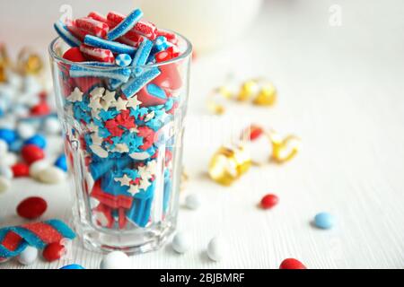 Glas mit bunten kleinen Süßigkeiten auf dem Tisch Stockfoto