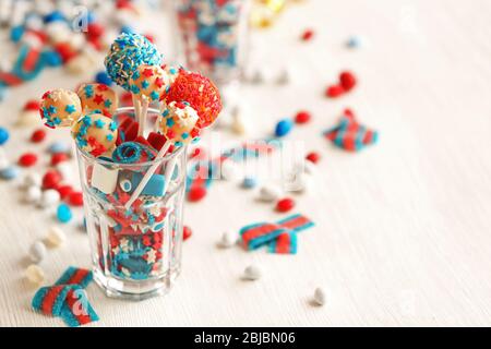 Glas mit bunten kleinen Süßigkeiten auf dem Tisch Stockfoto