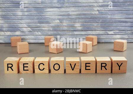 Word Recovery auf Holzblöcke auf Wand Hintergrund geschrieben Stockfoto