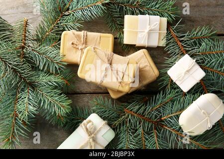 Stücke von Nadelseife und Äste auf Holzhintergrund Stockfoto