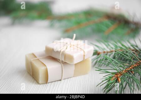 Stücke von Nadelseife und Äste auf Holzhintergrund, Nahaufnahme Stockfoto