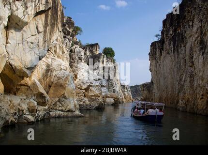 Jabalpur, Madhya Pradesh/Indien : 29. Januar 2020 - Touristen, die mit kleinen Holzbooten auf dem Narmada River (Marble Rocks) bei Bhedaghat fahren Stockfoto