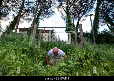 Eine Trainingseinheit von Massimiliano Cirillo in einem Park von Spinaceto, einem Viertel am südlichen Stadtrand von Rom, während der ItalyÕs-Sperre aufgrund der Covid-19-Pandemie. Massimiliano Cirillo ist ein Kampfkunstlehrer und ein High School Sportlehrer. Er verbringt die Hälfte der Zeit damit, seine Schüler online zu unterrichten und die andere Hälfte im Freien zu trainieren. Am 4. Mai wird die "Phase 2" der Maßnahmen gegen Pandemie, die von der italienischen Regierung beschlossen, und individuelle Ausbildung für Profisportler wieder erlaubt werden. Die Praxis des Breitensports und des Mannschaftssports bleibt verboten Stockfoto