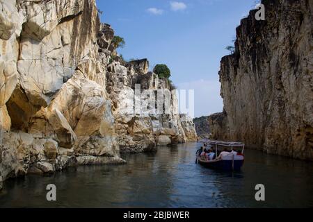 Jabalpur, Madhya Pradesh/Indien : 29. Januar 2020 - Touristen, die mit kleinen Holzbooten auf dem Narmada River (Marble Rocks) bei Bhedaghat fahren Stockfoto