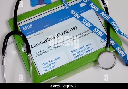 Coronavirus covid-19 Informationen auf nhs-Website auf Computer-Tablet mit Trageschlaufe und Stethoskop Stockfoto
