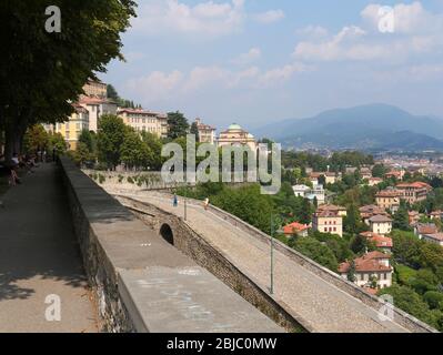 Bergamo, Italien - 1. August 2019: Panorama-Blick auf Bergamo Oberstadt von der alten Stadtmauer mit zwei Touristen fotografieren auf der berühmten Fußgängerzone Stockfoto