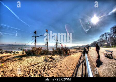 Stadt Wallasey, England. Künstlerische Silhouetten von New Brighton Promenade mit dem Piratenschiff Black Pearl im Hintergrund. Stockfoto