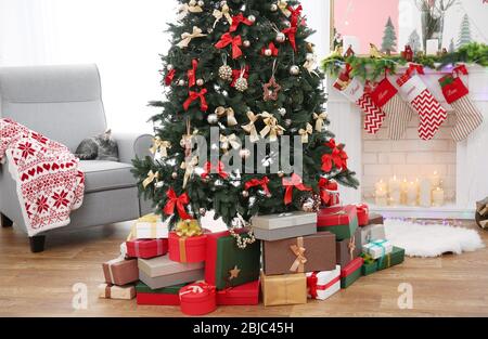 Schöner Weihnachtsbaum mit Geschenken im Wohnzimmer Stockfoto