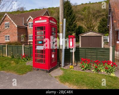 Eine rote Telefonbox und eine rote er-Briefbox nebeneinander im kleinen Dorf Thixendale in den Yorkshire Wolds. Stockfoto