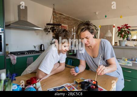 Mutter und Sohn Färbung Osterei zu Hause in der Küche Stockfoto