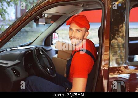 Liefermann mit Paketen im Auto Stockfoto