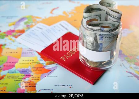 Pass mit Tickets und Geld für den Urlaub auf Weltkarte Hintergrund Stockfoto