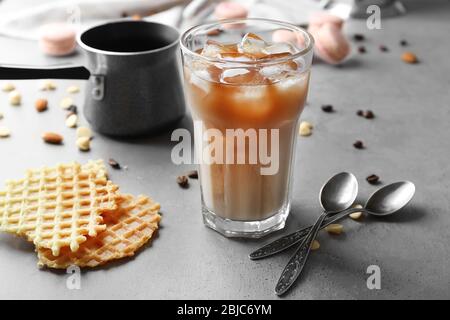 Ein Glas kalten Kaffee mit Waffeln auf dem Tisch Stockfoto