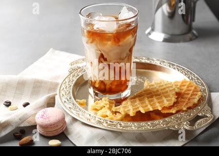 Ein Glas kalten Kaffees mit Waffeln auf dem Tablett Stockfoto