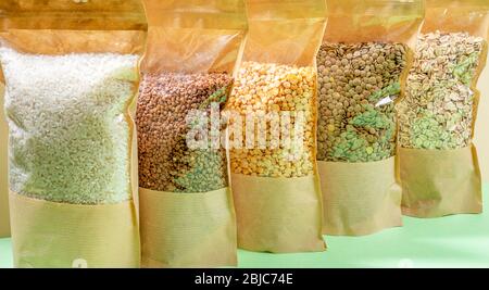 Papiertüten mit Zellophan voller Getreide und Hülsenfrüchte Nahaufnahme. Buchweizen, Erbsen, Linsen, Reis, Haferflocken. Konzept Der Lagerung Von Lebensmitteln Ohne Abfall. Kein Plast Stockfoto