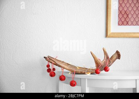 Dekoriertes Elchhorn auf weißem Tisch Stockfoto