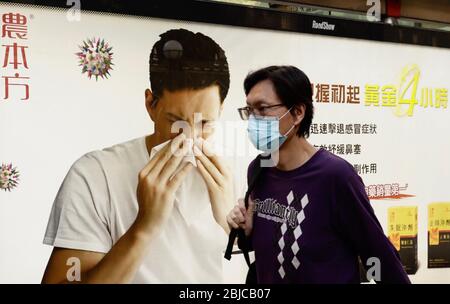 Hongkong, CHINA. April 2020. Maskierter Bürger gehen an einem Bild von Werbeplakat vorbei. Die Regierung von Hongkong hat angekündigt, dass es "keinen neuen Fall für eine Coronavirus-Infektion mit Zertifikat für den 4. Tag" gibt.29. April 2020 Hongkong.ZUMA/Liau Chung-ren Quelle: Liau Chung-ren/ZUMA Wire/Alamy Live News Stockfoto