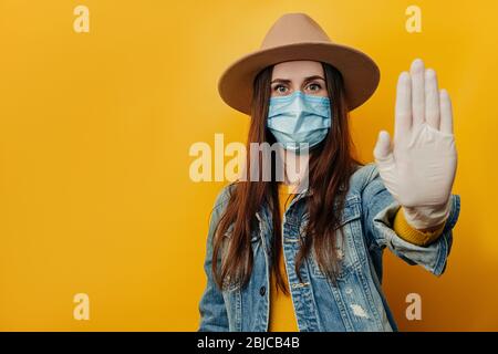 Serious Reisenden touristischen Frau in medizinischen sterilen Gesichtsmaske Handschuhe, zeigen Stop Geste, versuchen, den Konflikt zu regeln, während Pandemie Coronavirus, ich Stockfoto