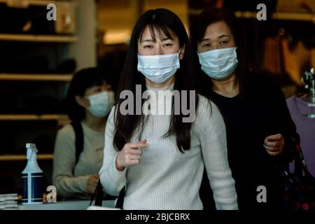 Tokio, Japan. März 2020. Passanten, die Gesichtsmasken tragen, um gegen Coronavirus zu schützen, schauen sich während der Sperrung im GU-Geschäft des Schnellhandels um, um Kleidung zu suchen.das Gesundheitsministerium von JapanÃ verzeichnete insgesamt 13,852 Infektionen, 389 Todesfälle und 3,374 wurden seit Beginn des Ausbruchs geheilt. Kredit: James Matsumoto/SOPA Images/ZUMA Wire/Alamy Live News Stockfoto