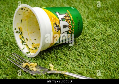 Leere und weggeworfene Pot Noodle Chicken and Mushroom Flavor Snack Pot, isoliert auf weißem Hintergrund. Pot Noodle wird von Unilever hergestellt Stockfoto