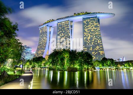 Singapur 02. Januar 2020 : Gärten an der Bucht mit den Superbäumen in der Nacht, im Hintergrund das Marina Bay Sands Hotel Stockfoto