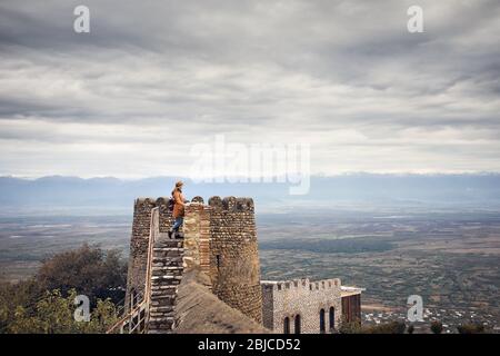 Touristische Frau an der Festung Turm Wand aus Stein mit Blick auf die Berge in Signagi, Georgien Stockfoto