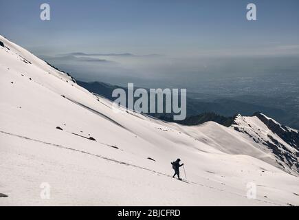 Touristische im Schnee weg in die schönen Berge im Winter mit Blick auf die Stadt Stockfoto