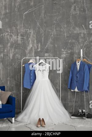 Brautkleid und Bräutigam Anzug in Ankleidezimmer drinnen Stockfoto