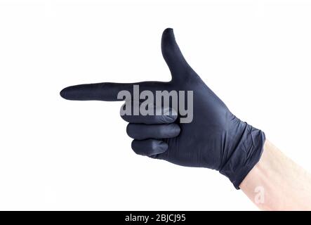 Hand in schwarzen schützenden Einweg-Gummihandschuh, der eine Fingerpistole Geste macht, auf etwas zeigend, isoliert auf Weiß, ausgeschnitten Stockfoto