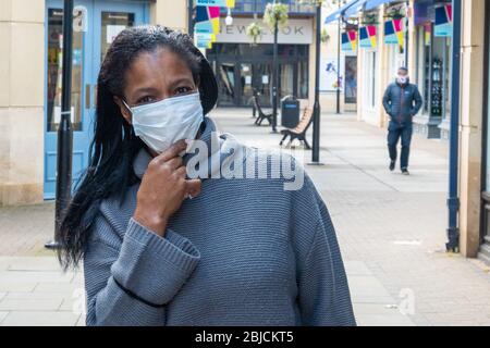 Eine Frau posiert auf der Straße und trägt eine Gesichtsmaske Stockfoto