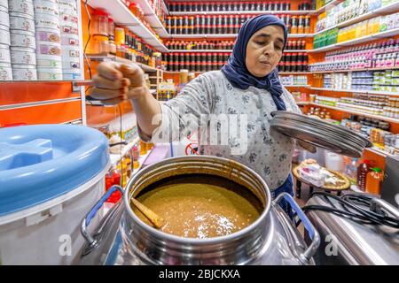 Agadir, Marokko - 19. März 2020: Frau, die frisch zubereitete, Bio-Erdnussbutter auf dem Markt in Afrika verkauft Stockfoto