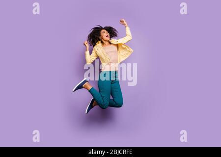 Gedreht in voller Länge Körpergröße Foto von fröhlichen ekstatisch überglücklich in Hosen Hosen Schuhe gestreiften T-Shirt isoliert Pastell Farbe violett Hintergrund Stockfoto