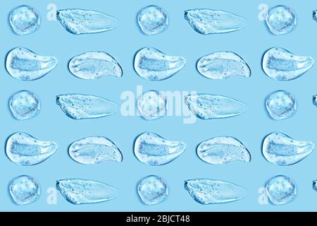 Eine Gruppe transparenter Gelschmierungen auf blauem Hintergrund. Virenschutz- oder Kosmetikkonzept. Schleifenelemente. Stockfoto