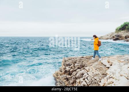 Frau, die auf der Klippe steht und auf das Meer blickt Stockfoto