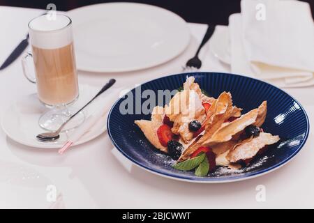 Französische dessert Blätterteig Blätterteig, überlagert mit Pudding Sahne, Himbeeren, Blaubeeren auf einem Schild an einer konkreten Tabelle, Ansicht von oben, in der Nähe Stockfoto