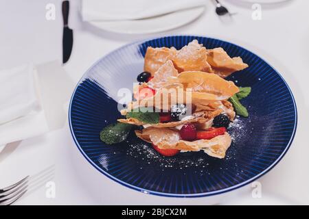 Französische dessert Blätterteig Blätterteig, überlagert mit Pudding Sahne, Himbeeren, Blaubeeren auf einem Schild an einer konkreten Tabelle, Ansicht von oben, in der Nähe Stockfoto