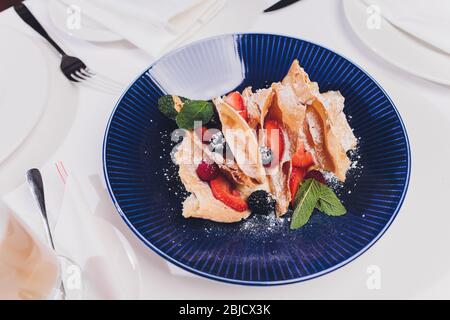 Französische dessert Blätterteig Blätterteig, überlagert mit Pudding Sahne, Himbeeren, Blaubeeren auf einem Schild an einer konkreten Tabelle, Ansicht von oben, in der Nähe Stockfoto